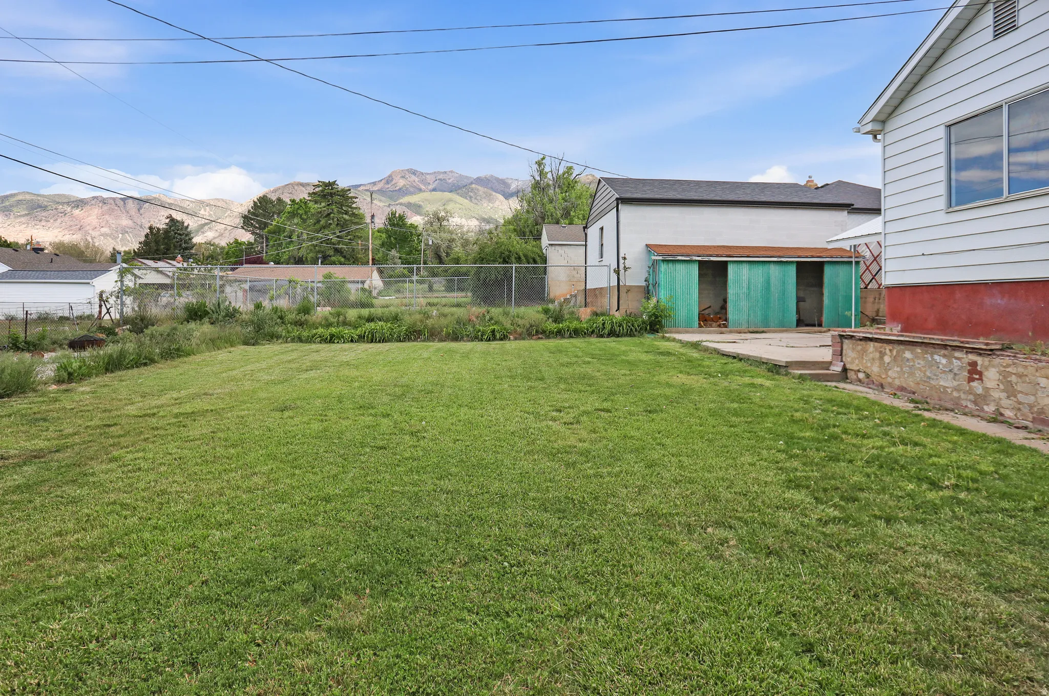 Expansive green lawn with a chain-link fence border