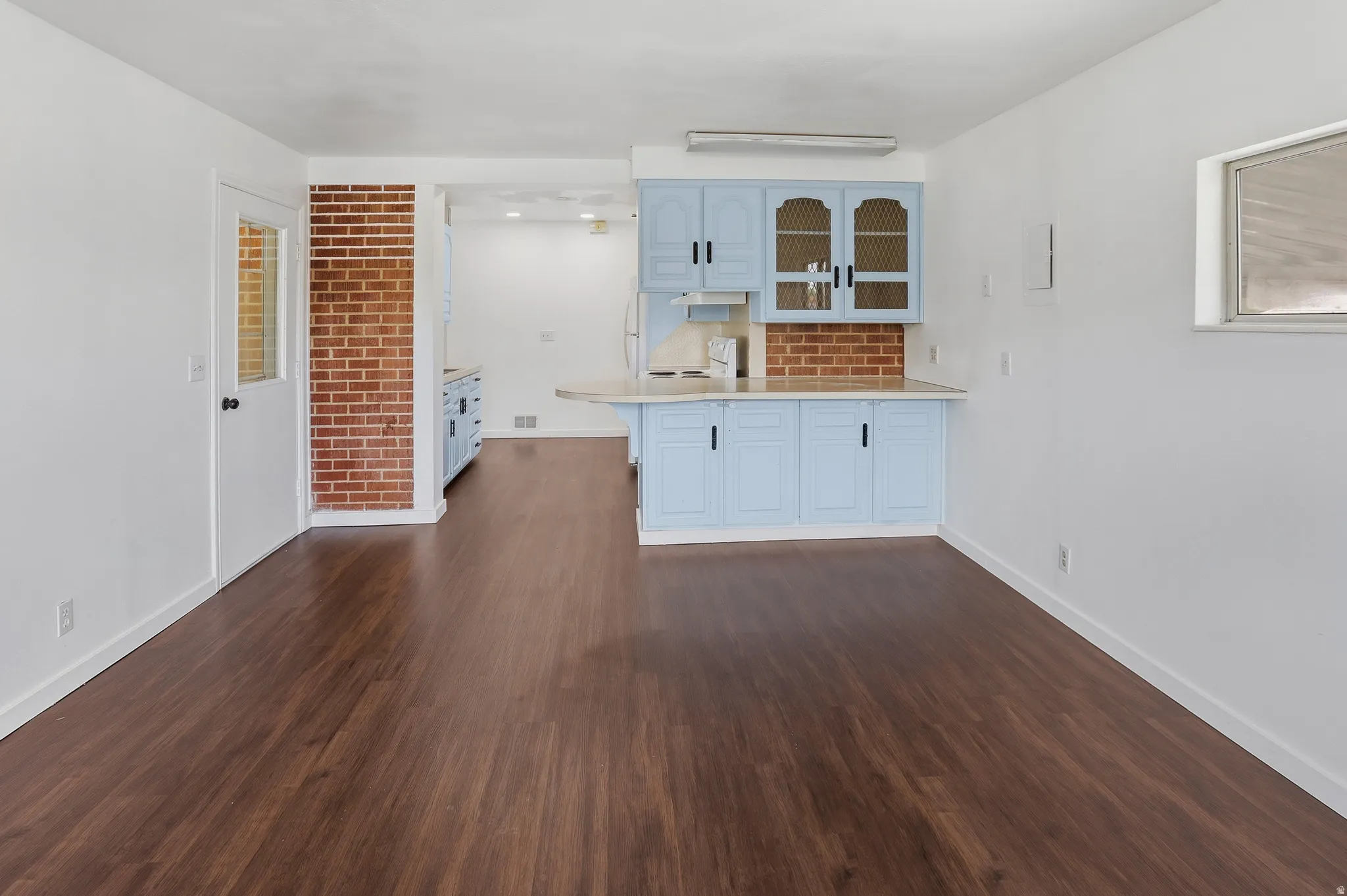 Open-concept living area with dark wood-finish flooring