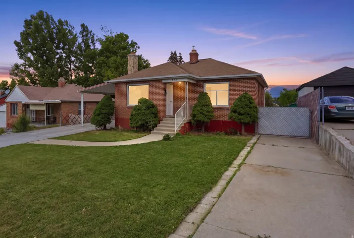Brick exterior with a peaked roofline, front porch, and mature landscaping