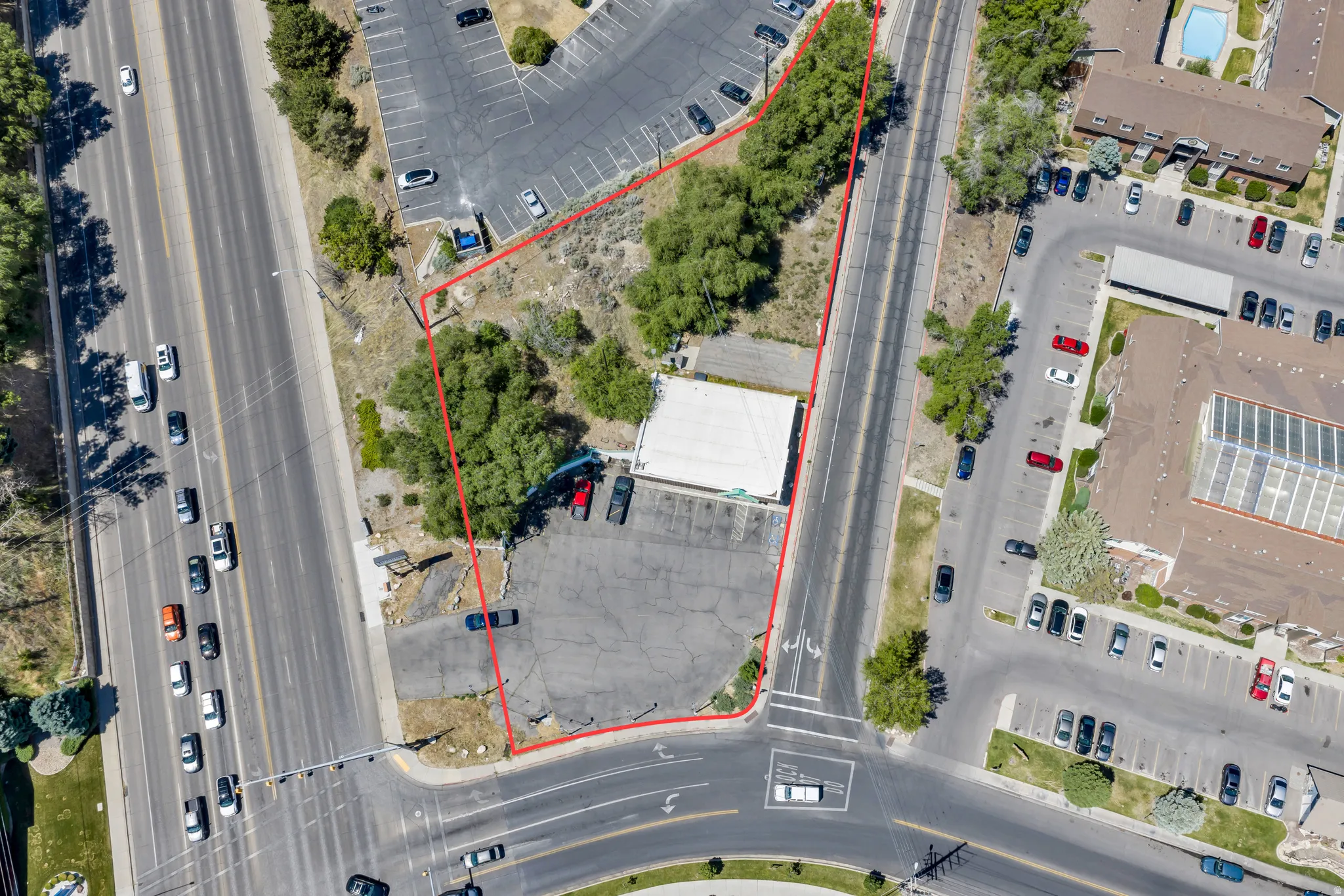 Commercial lot featuring direct street frontage on a multi-lane thoroughfare, paved parking, and a visible building structure