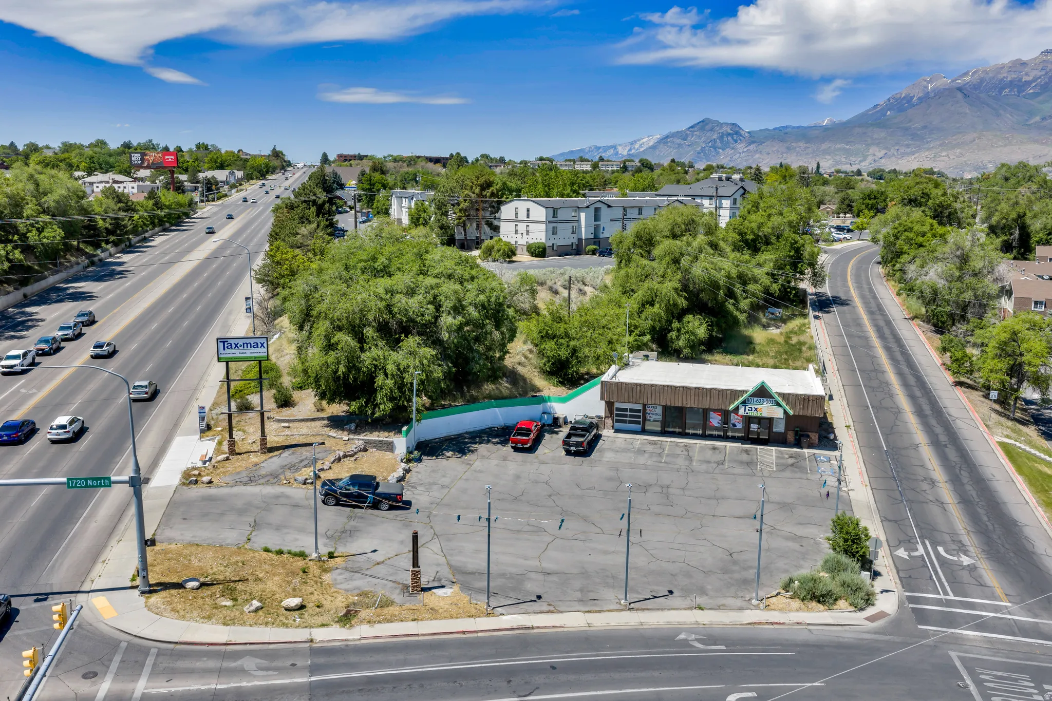 Commercial building with multiple garage bays, prominent street frontage, and a large paved parking area