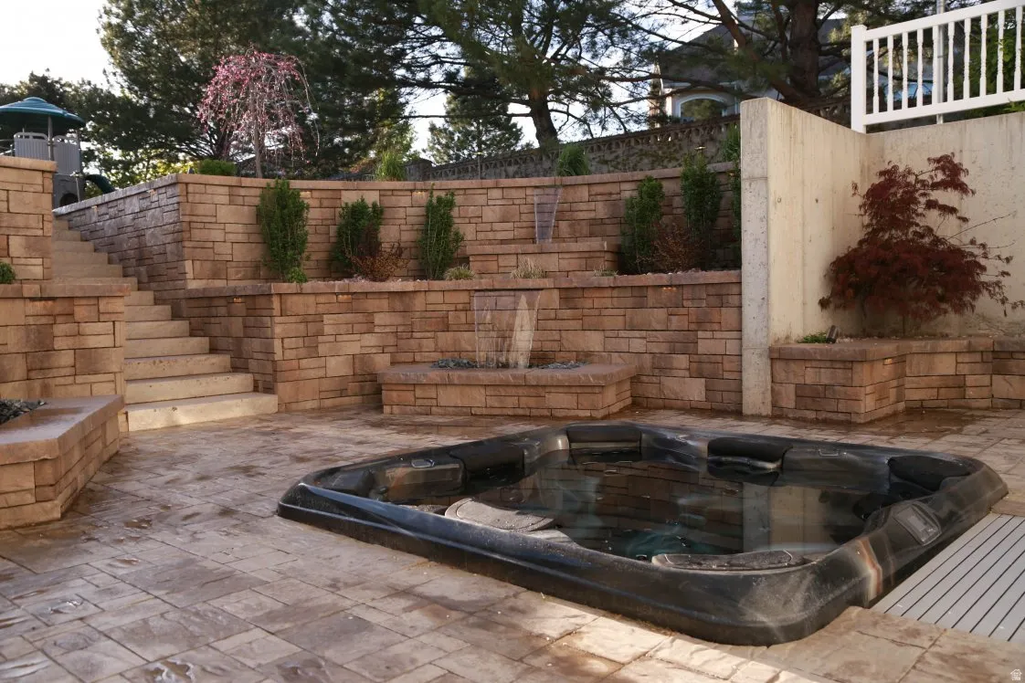 In-ground spa with surrounding stamped concrete patio