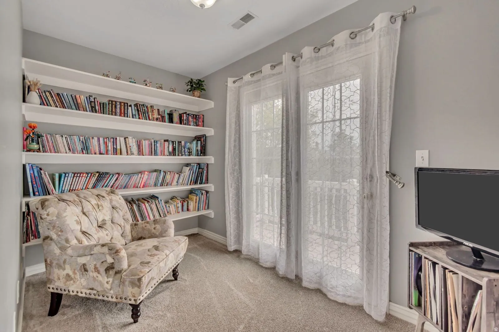 Built-in wall shelving providing ample storage, complemented by a pair of glass panel doors offering natural illumination