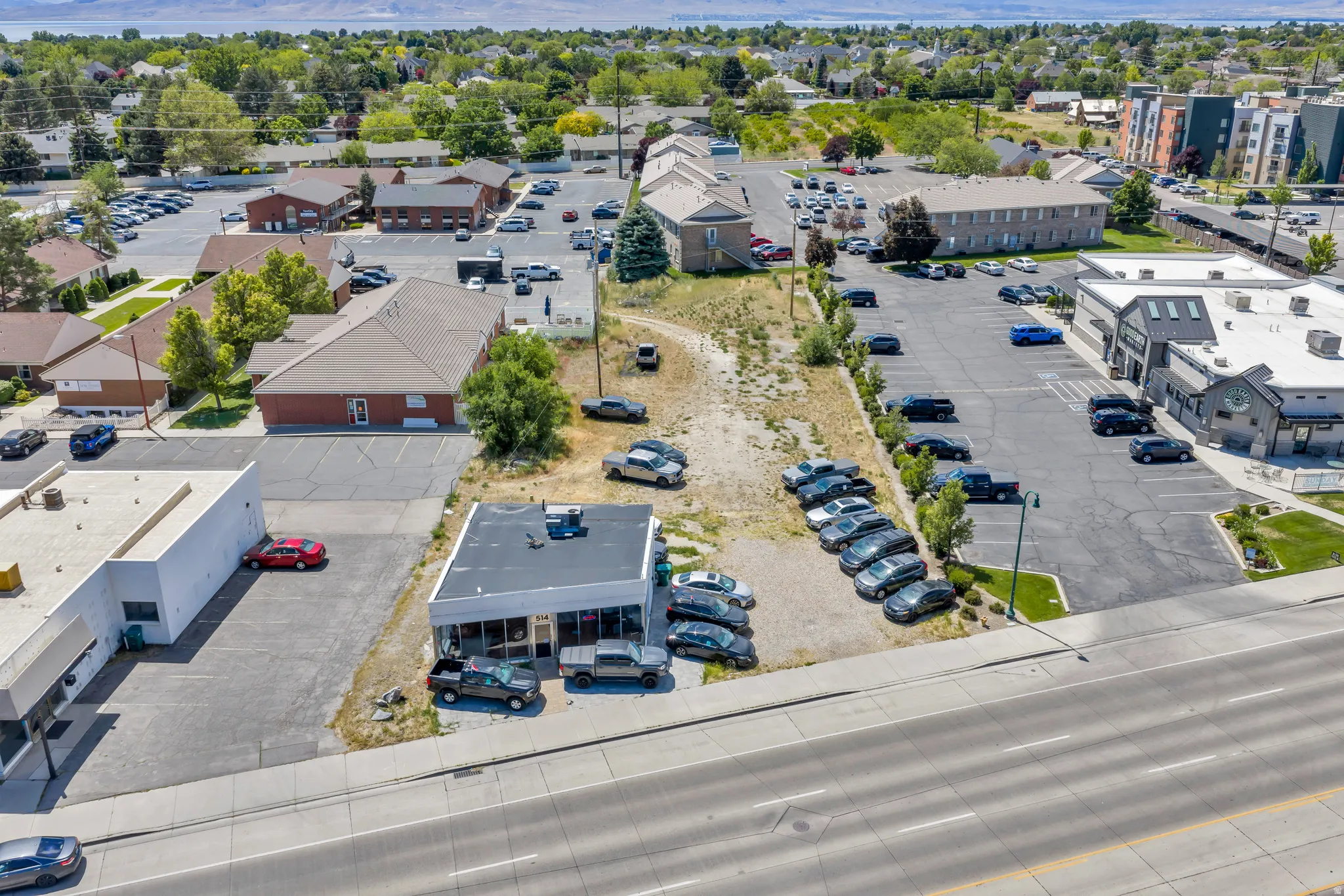 Commercial property featuring a single-story building with a flat roof and extensive glass storefront, positioned along a multi-lane roadway
