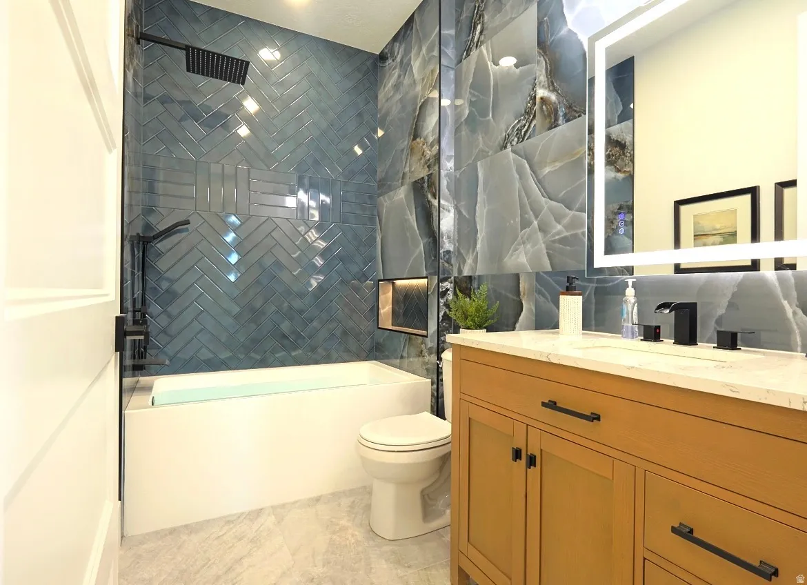 Contemporary bathroom featuring a light wood-finish vanity with black hardware, a rectangular undermount sink, and a light-toned countertop