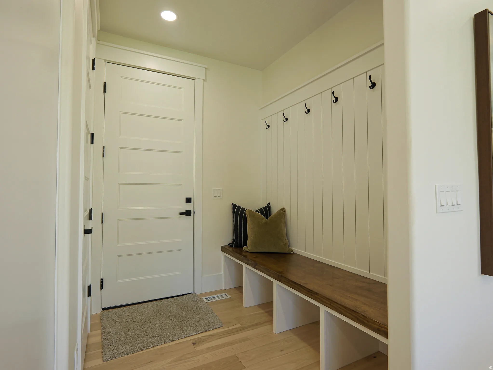 Entryway mudroom featuring a built-in bench with a wood-finish top and white cubbies