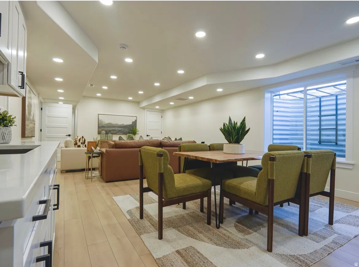 Spacious living area featuring light wood-finish flooring and recessed lighting throughout