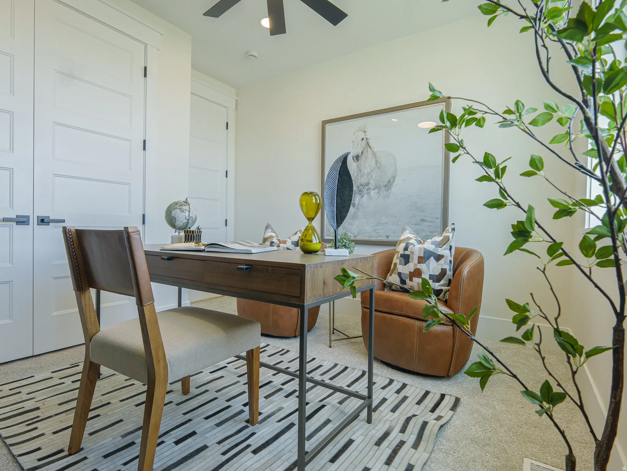 Versatile room featuring light-colored carpeting, white paneled doors with dark hardware, and a ceiling fan