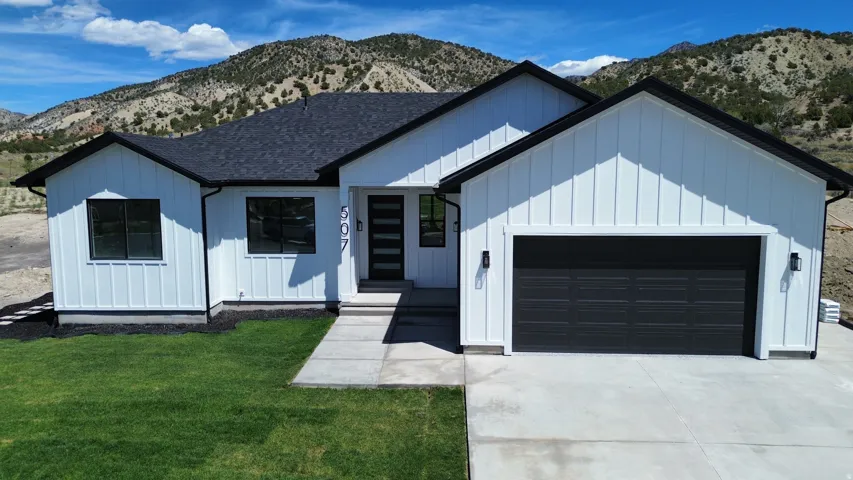 Contemporary ranch-style residence featuring white board-and-batten siding with black trim accents