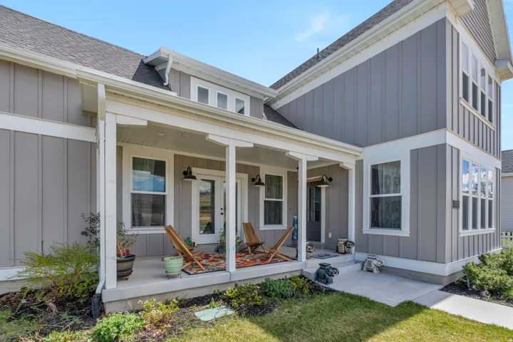Property entrance featuring board and batten siding, a shingled roof, a porch, and a lawn