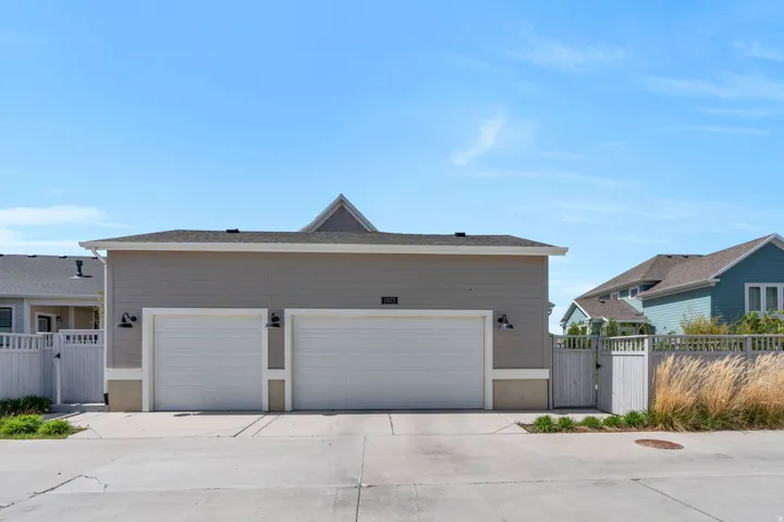 View of front of property featuring a gate, driveway, and a garage