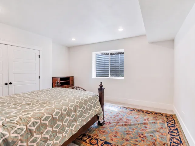 Recessed lighting, window, white walls, and built-in closet with panel doors