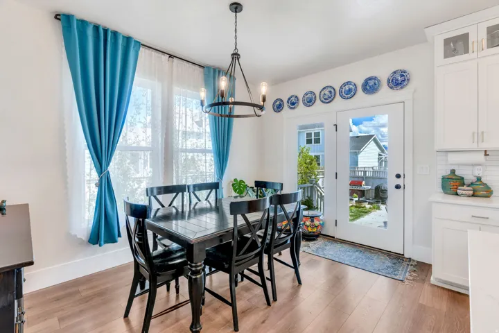 Dining room with light wood finished floors and hanging lights
