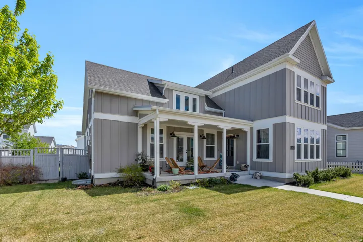 View of front of house featuring a gate, roof with shingles, board and batten siding, and a front lawn