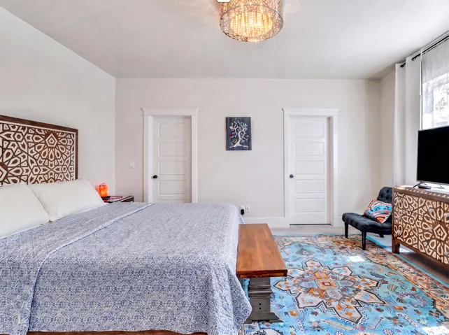 Textured ceiling, ornamental ceiling light fixture, white interior doors, and window with white privacy curtains