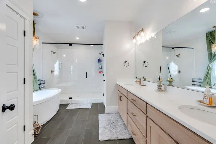 Bathroom featuring double vanity, a freestanding bath, a stall shower, and recessed lighting