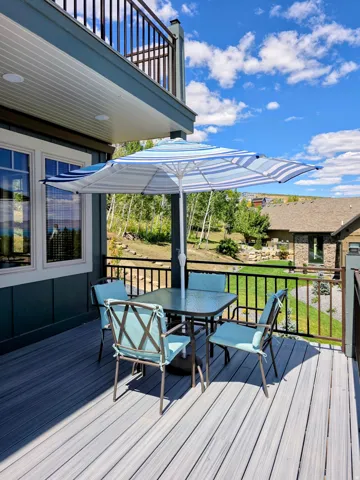 Main level deck faces the Bear Lake. This is the south side view off the deck with a great room access door. Spacious outdoor deck featuring composite decking, black iron coated metal railings.  You have so much privacy being a the last home on the the de
