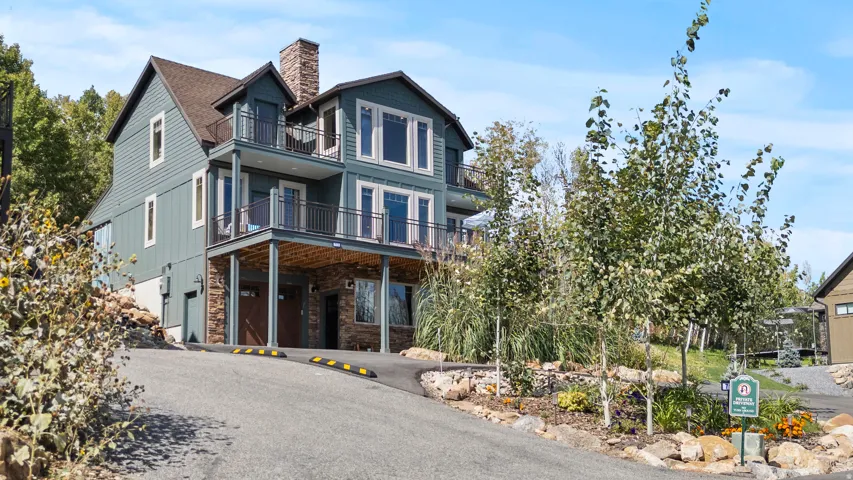 Multi-level residence featuring a prominent stone chimney, multiple balconies with iron coated railings, and large circular private drive-way at end of street.  It will NOT go through.