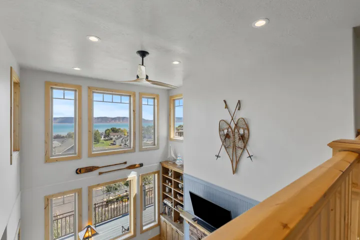 Vaulted ceilings with recessed lighting and a ceiling fan from open balcony of loft over upstairs over the great room.