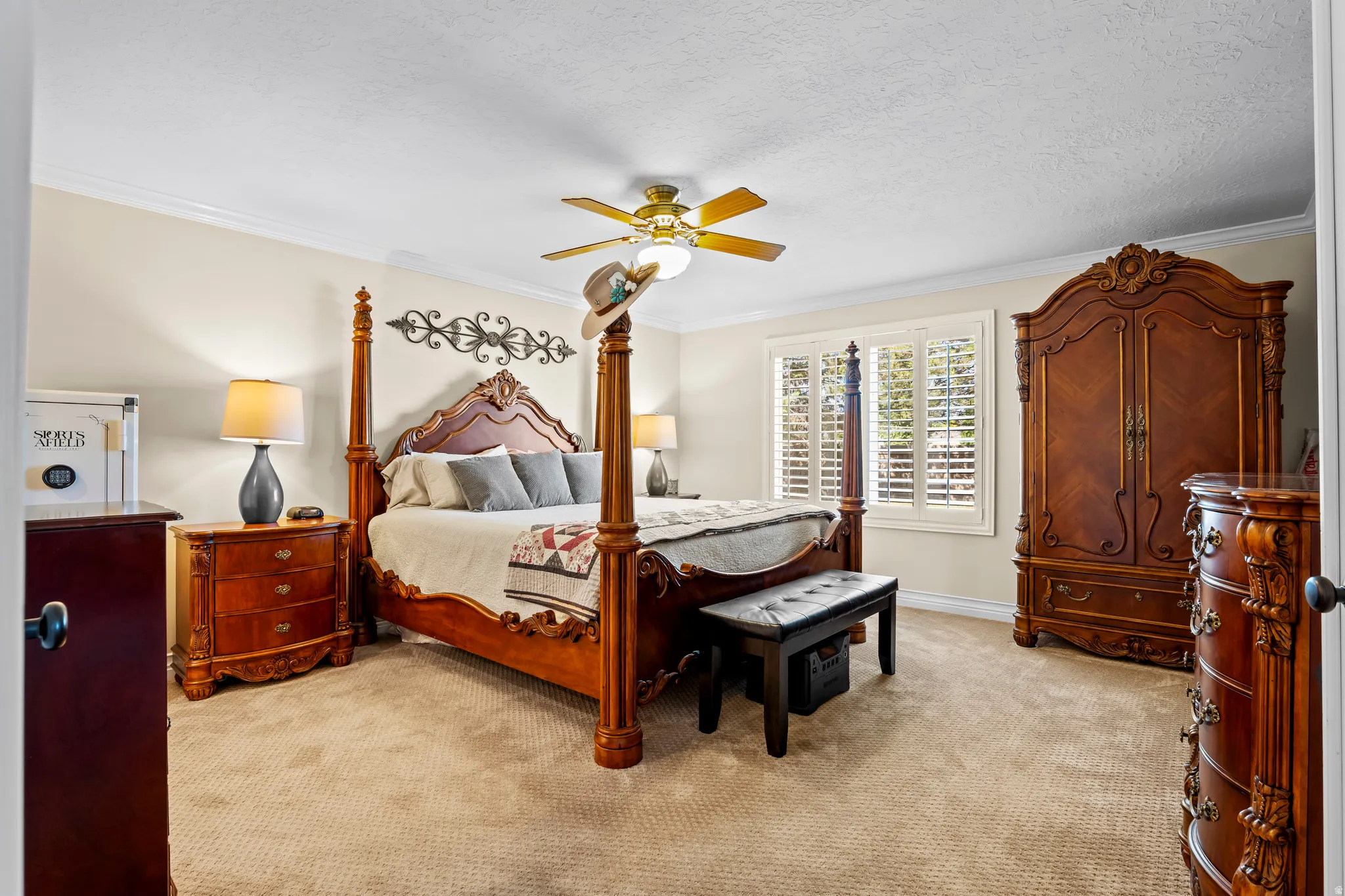 Spacious room featuring neutral carpeting, crown molding, and a ceiling fan with integrated lighting