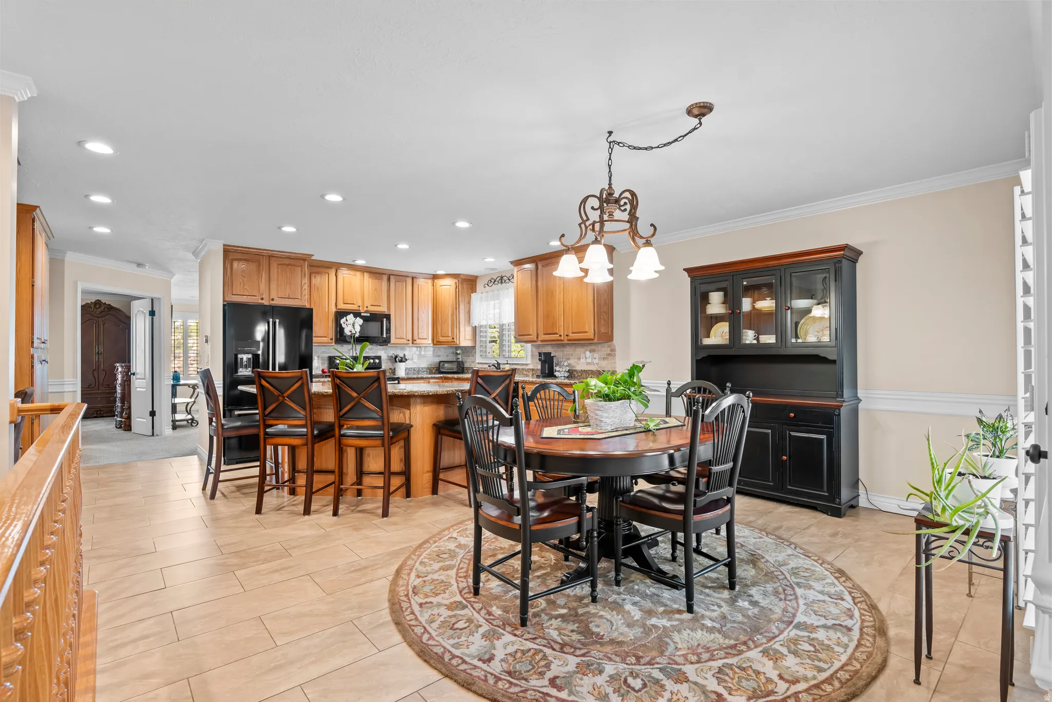 Open-concept kitchen and dining area featuring warm wood cabinetry, a breakfast bar with seating, and a decorative chandelier