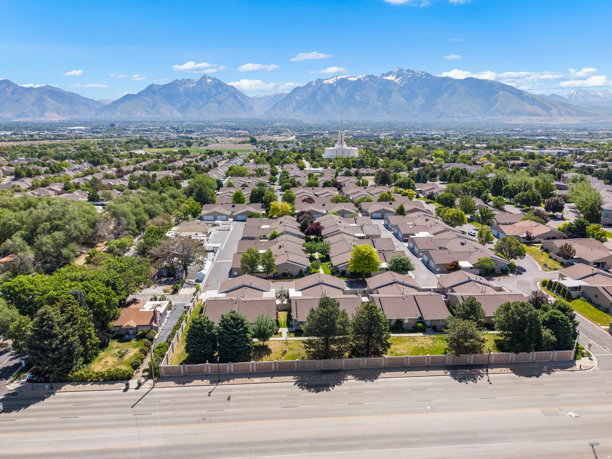 Expansive residential area with mature trees, surrounded by a mountain range