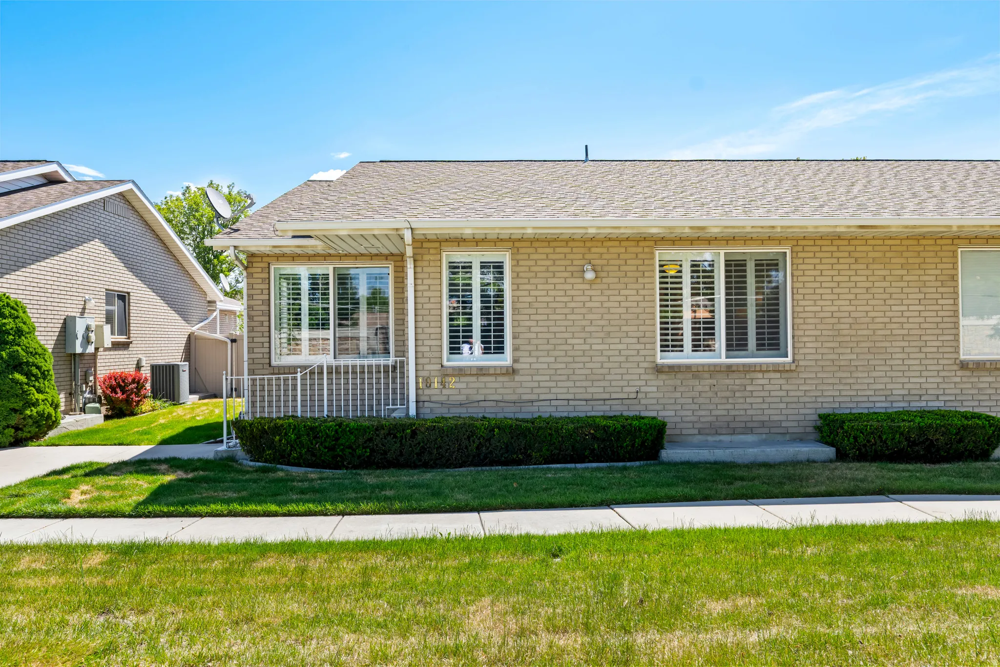 Light brick exterior with a pitched shingle roof