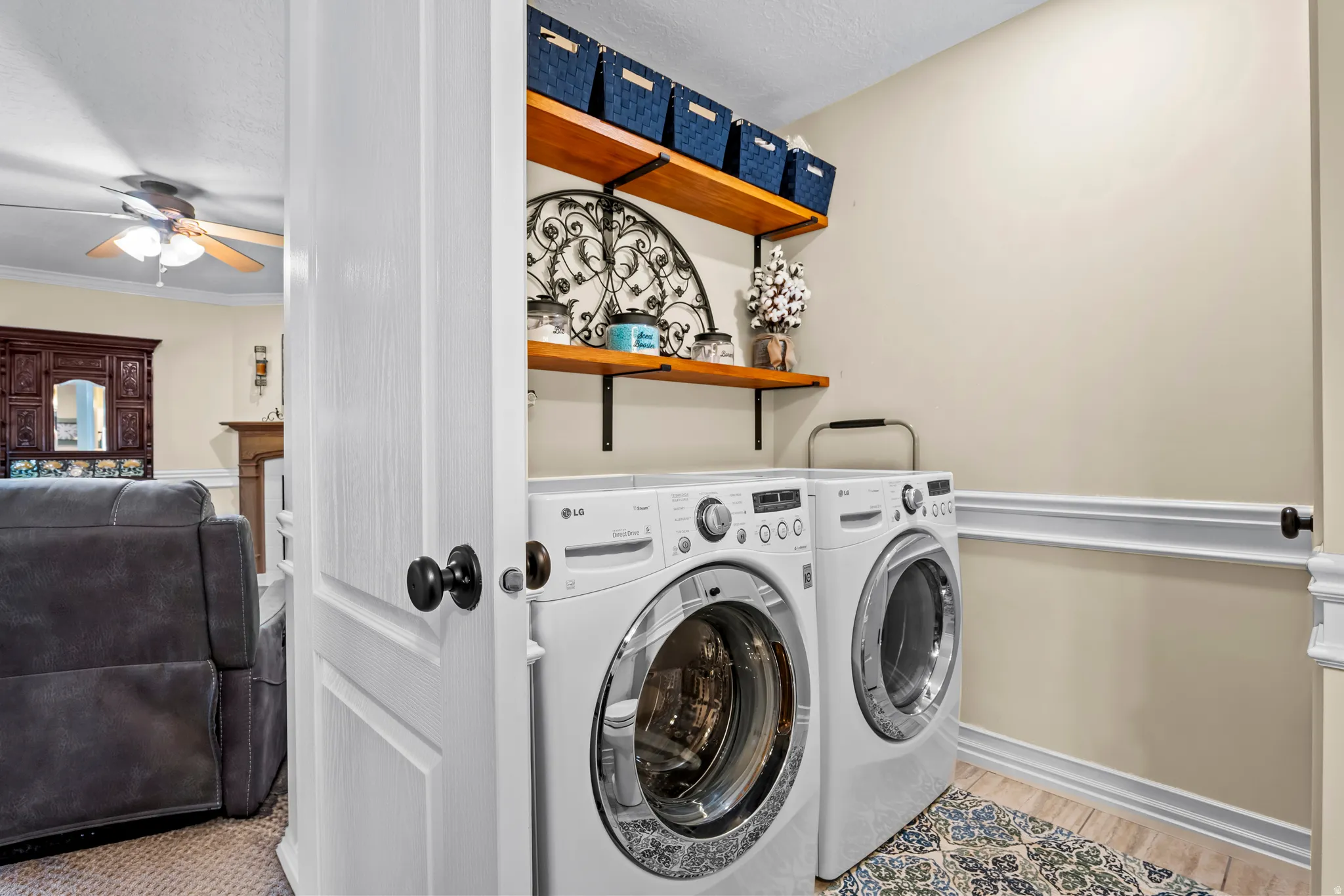 Dedicated laundry area with light-toned walls and wood-finish flooring
