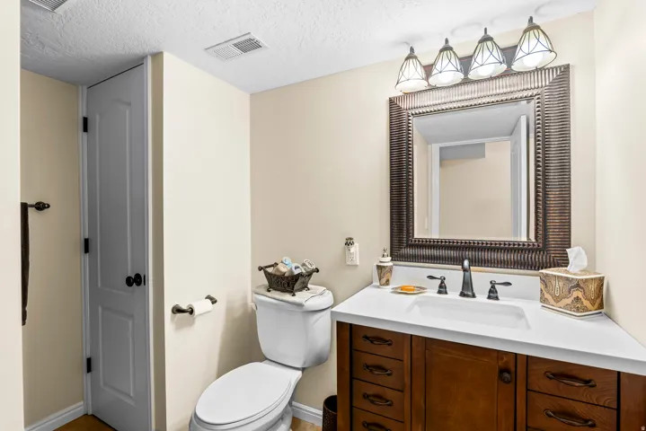 Bathroom vanity featuring a white countertop, undermount sink, and dark bronze faucet with matching hardware