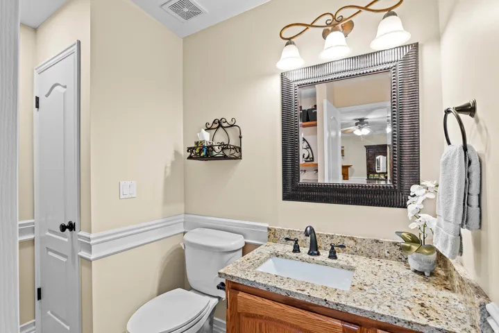 Bathroom vanity featuring a granite countertop, undermount sink, and matte black faucet