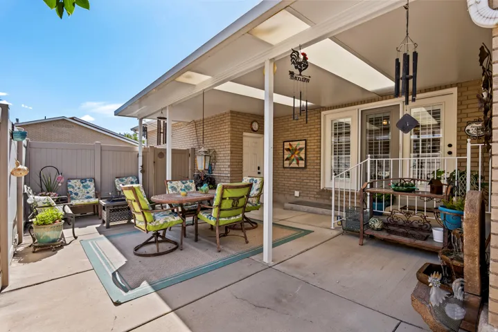 Patio with a white aluminum patio cover featuring translucent panels, a privacy fence, and a brick exterior