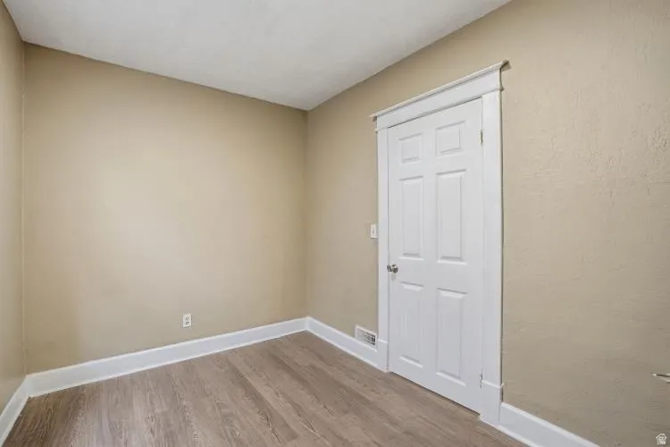 Den/Office space featuring wood-finish flooring, neutral wall tones, and white trim
