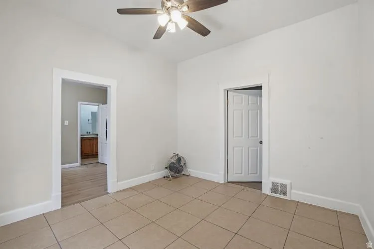 Neutral-toned room with square tile flooring and white baseboards