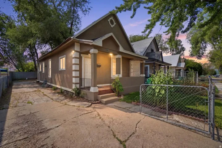 Exterior featuring a covered porch with column supports and a decorative gable