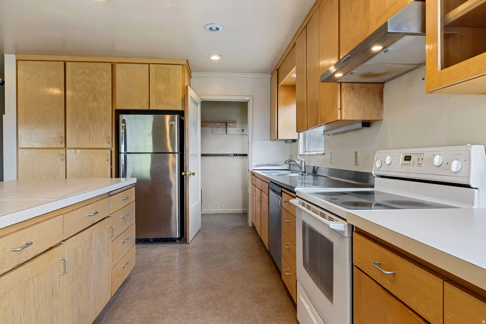 Kitchen featuring light wood cabinetry, white countertops, stainless steel refrigerator, white electric range, and recessed lighting