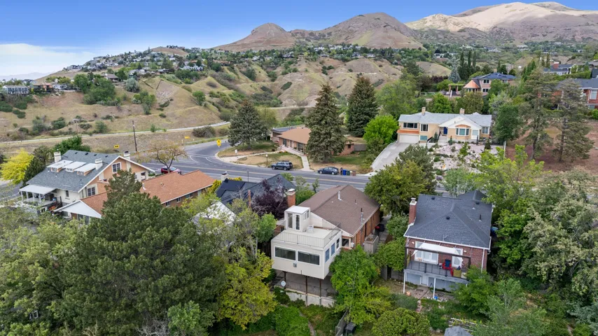 Expansive aerial perspective showcasing a residential area nestled against a mountainous backdrop