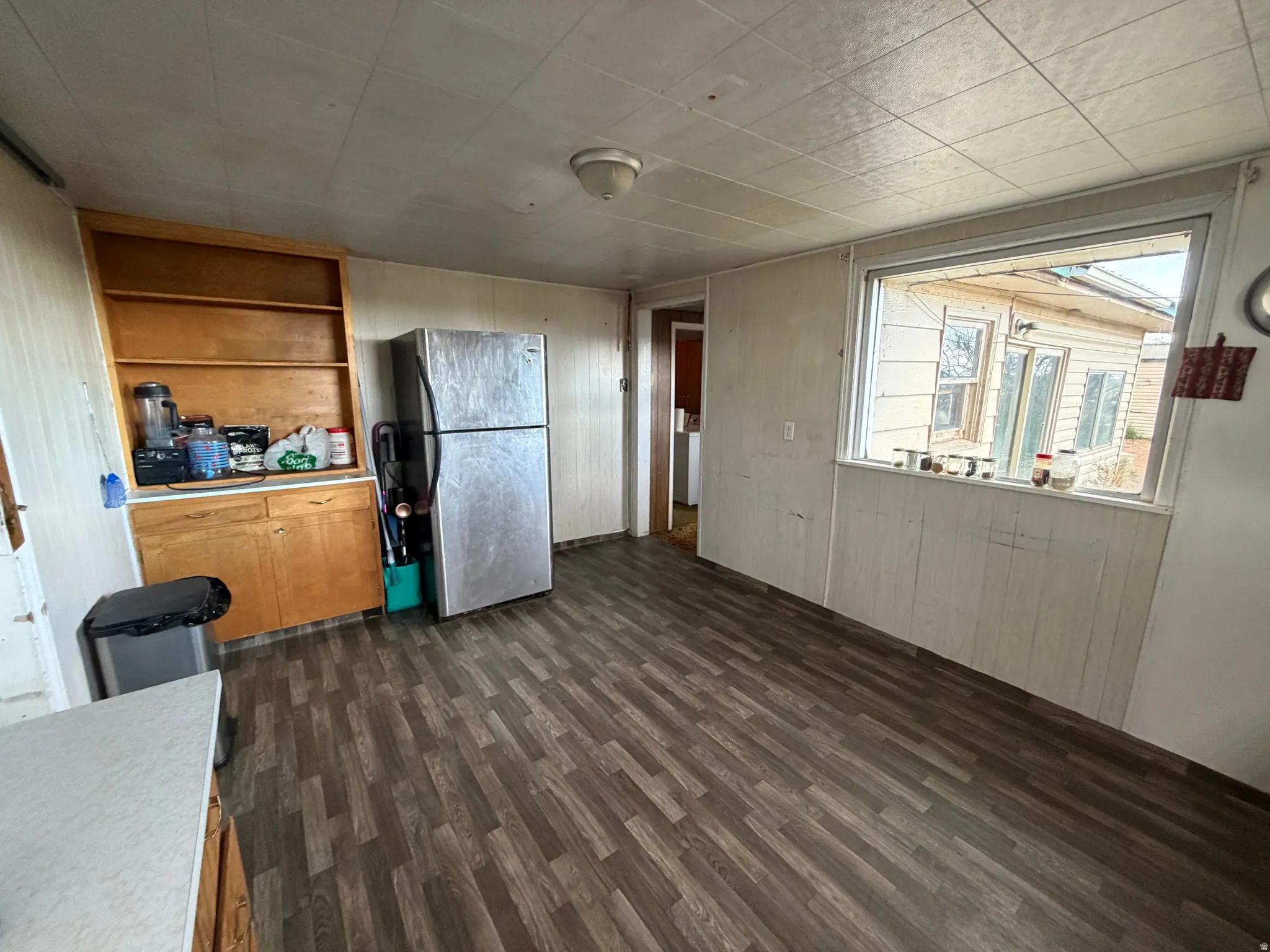 Kitchen featuring wood-finish flooring, a built-in wooden shelving unit, recessed lighting, and a large window
