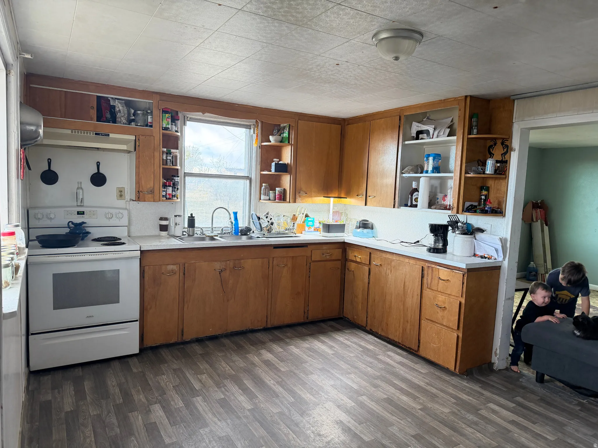 Kitchen featuring wood-finish cabinetry, a white countertop, and a white range