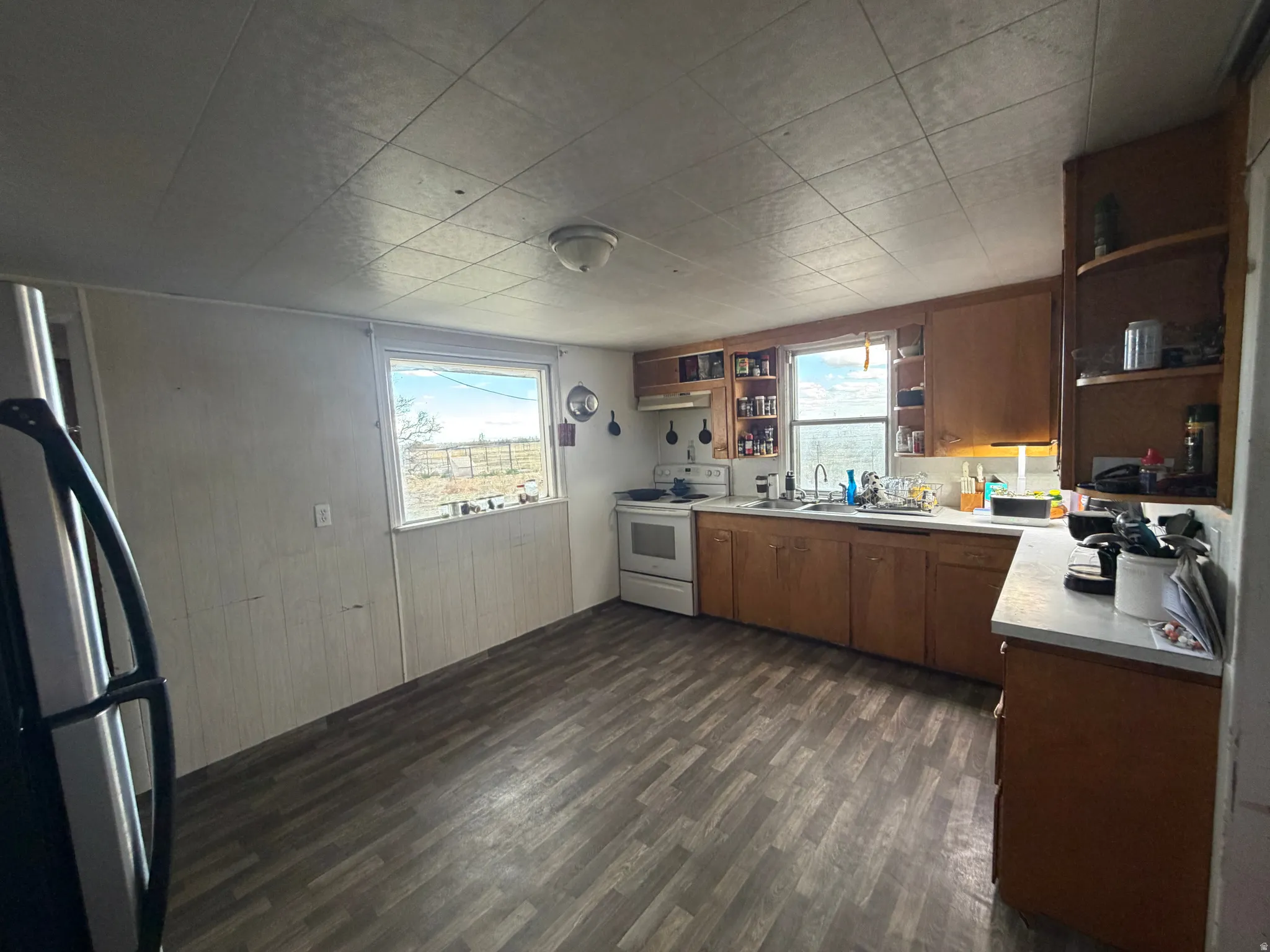 Kitchen featuring wood-finish flooring, wood cabinetry, white countertops, and dual windows
