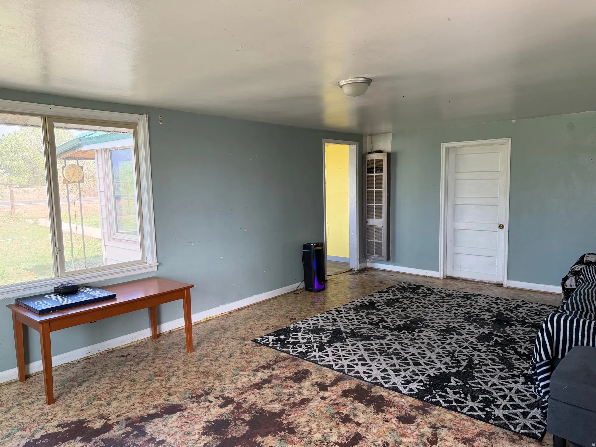 Interior room featuring light blue walls, multiple white panel doors, and a window with white trim