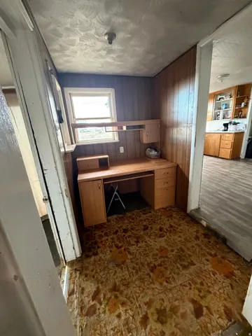 Dedicated workspace featuring wood-panel walls and a built-in desk with storage