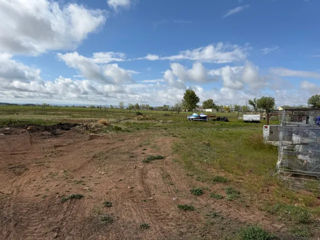 Expansive open land featuring a mix of cleared earth and natural grassland