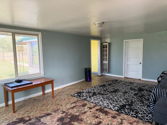 Interior room featuring light blue walls, multiple white panel doors, and a window with white trim