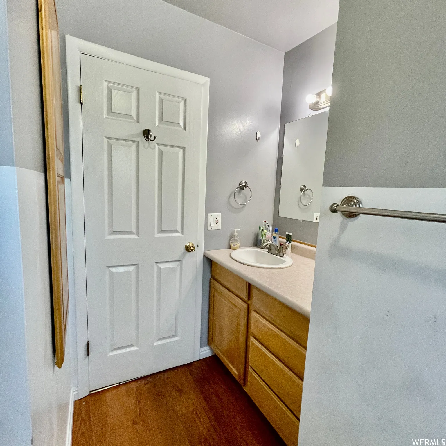 Bathroom vanity featuring a light-toned countertop, undermount sink, and wood-finish cabinetry with multiple drawers