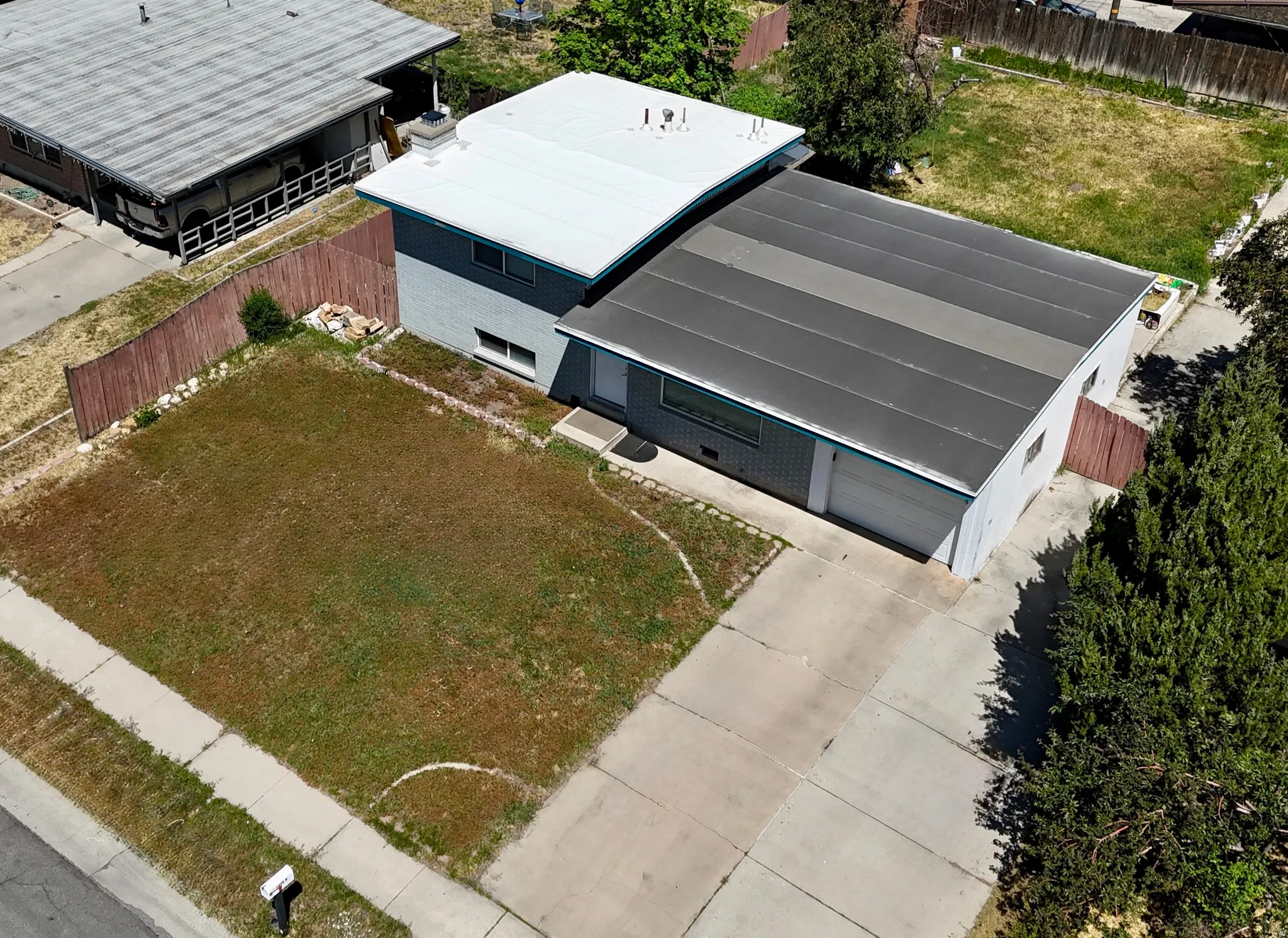 Two-story residence with a light gray brick exterior and a white roof