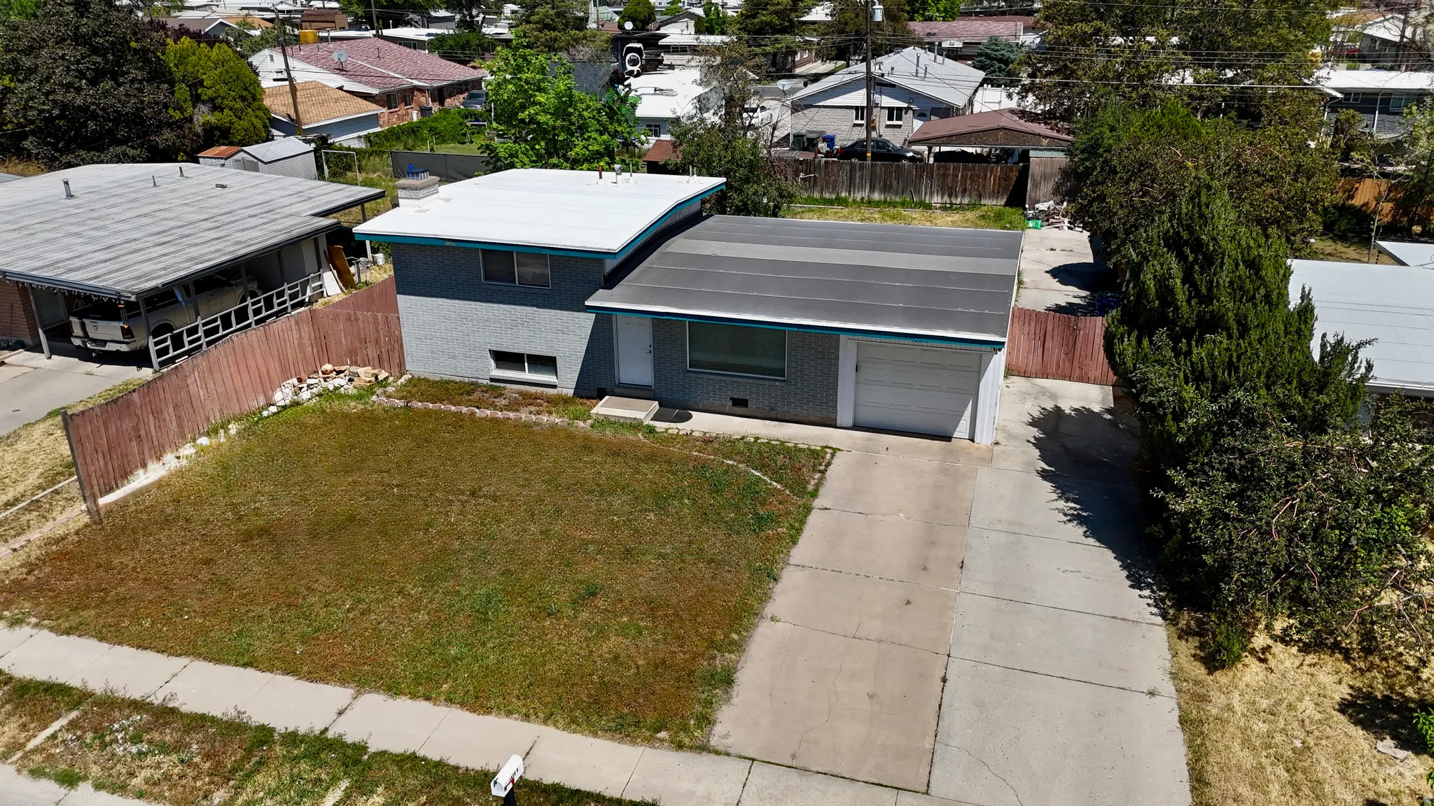 Single-story residence featuring a two-car garage, concrete driveway, and a fenced front yard