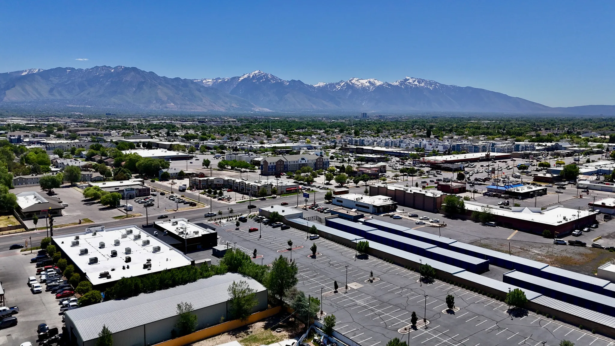 Commercial property featuring multiple buildings with flat roofs and extensive paved parking areas