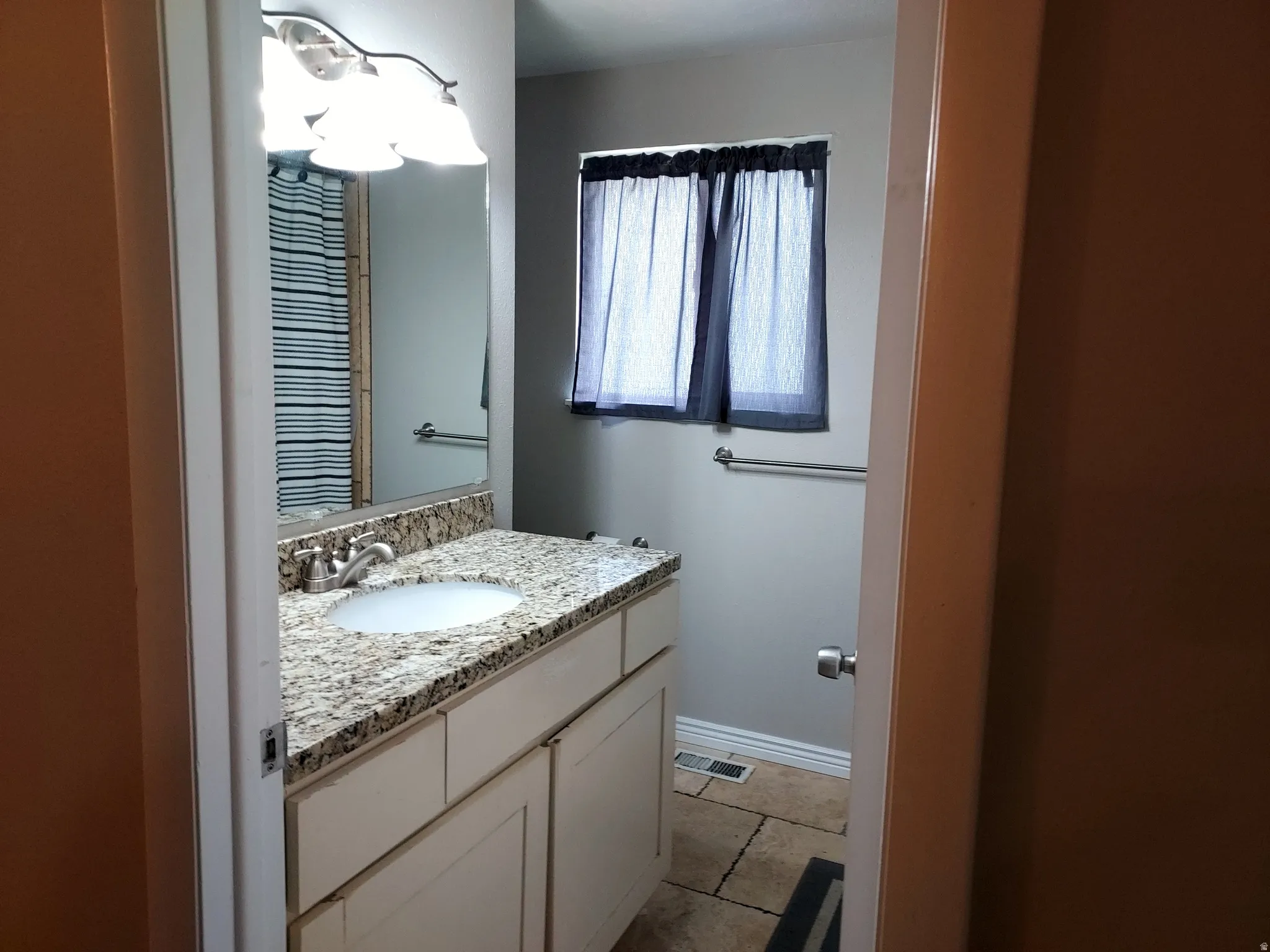 Half bathroom featuring vanity and baseboards