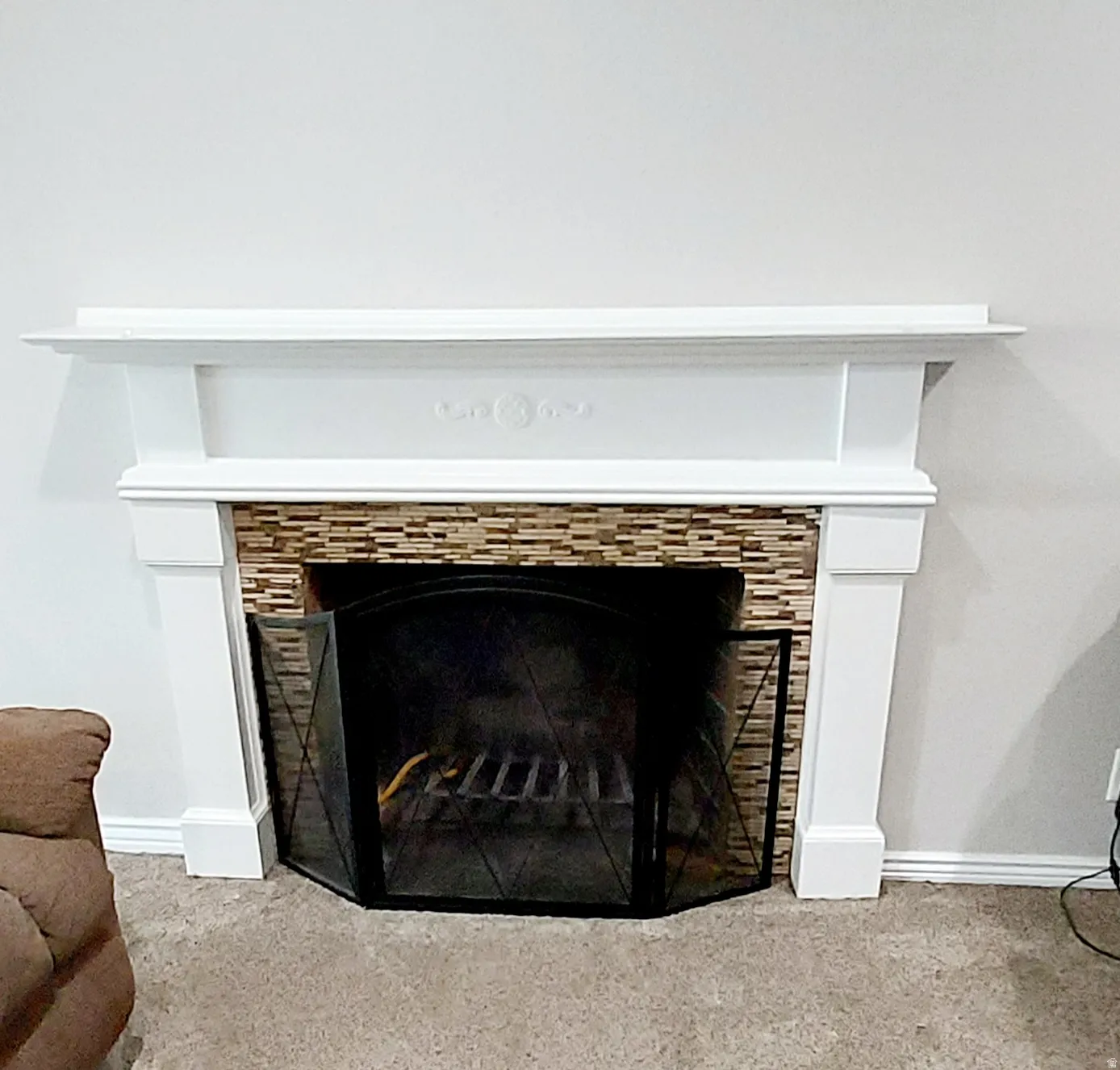 Detailed view of a tile fireplace and baseboards
