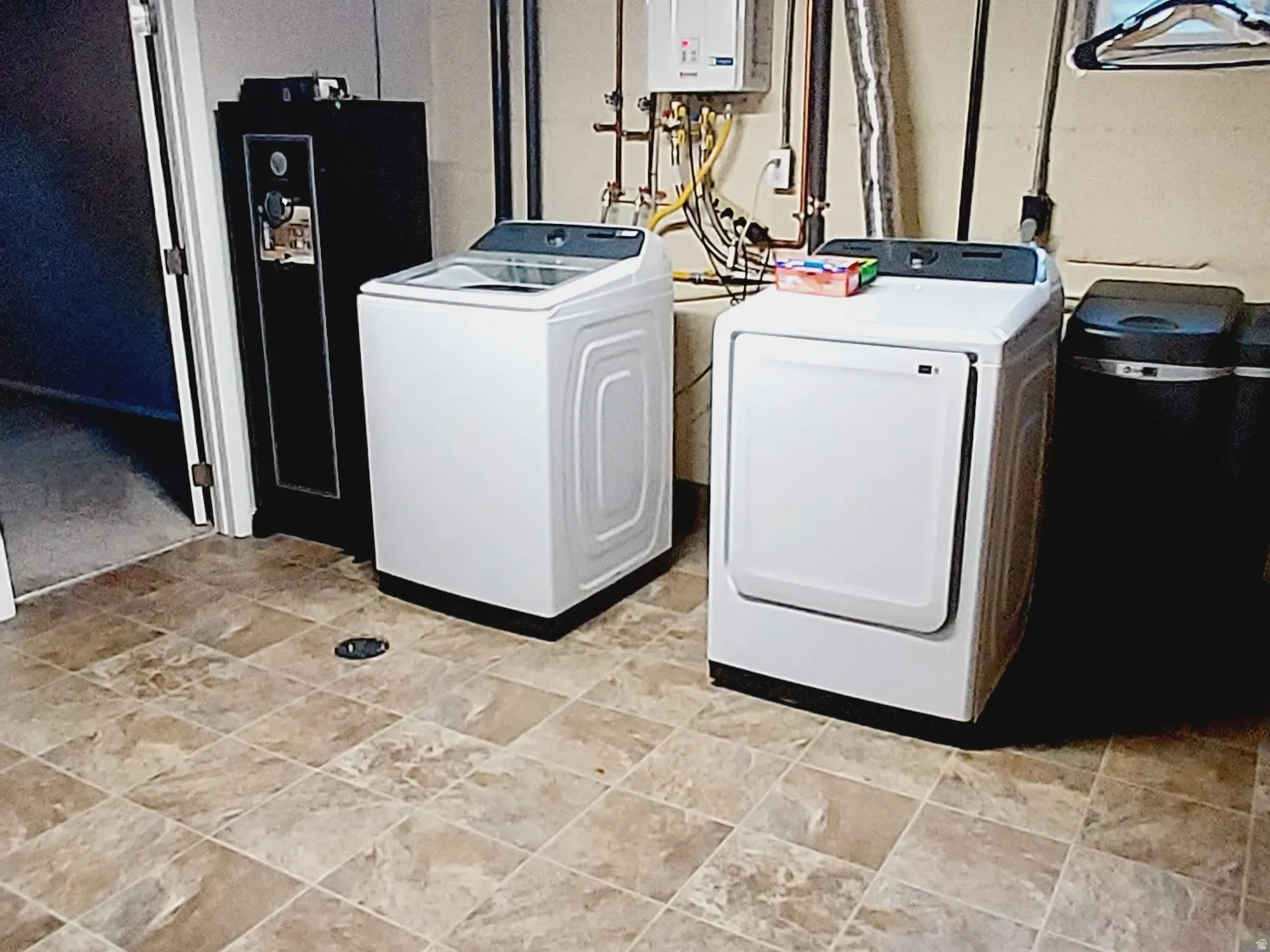 Laundry area with washing machine and dryer and water heater